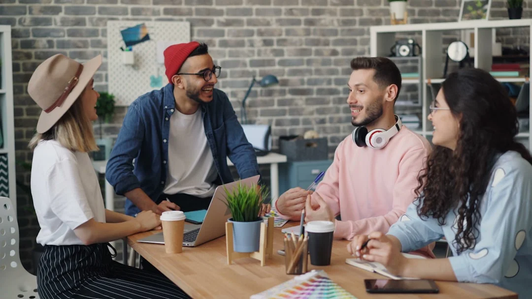 Vue du dessus d’une équipe collaborant avec des ordinateurs portables, des téléphones et des notes dans un bureau moderne.